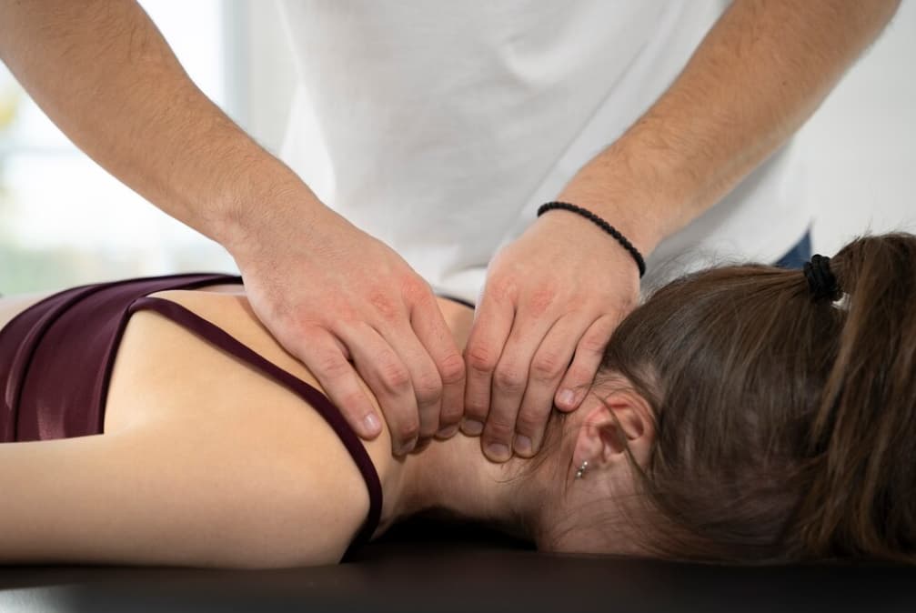 A chiropractor is applying treatment to a patient's lower back